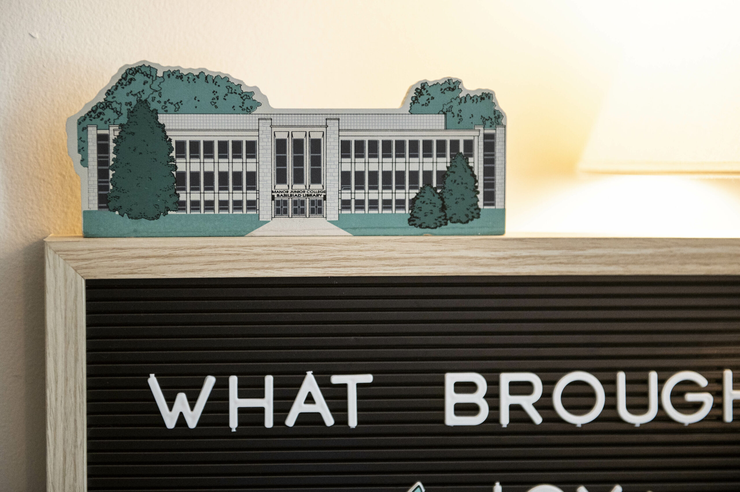 A wooden cut out depicting Manor College's Basileiad Library on display