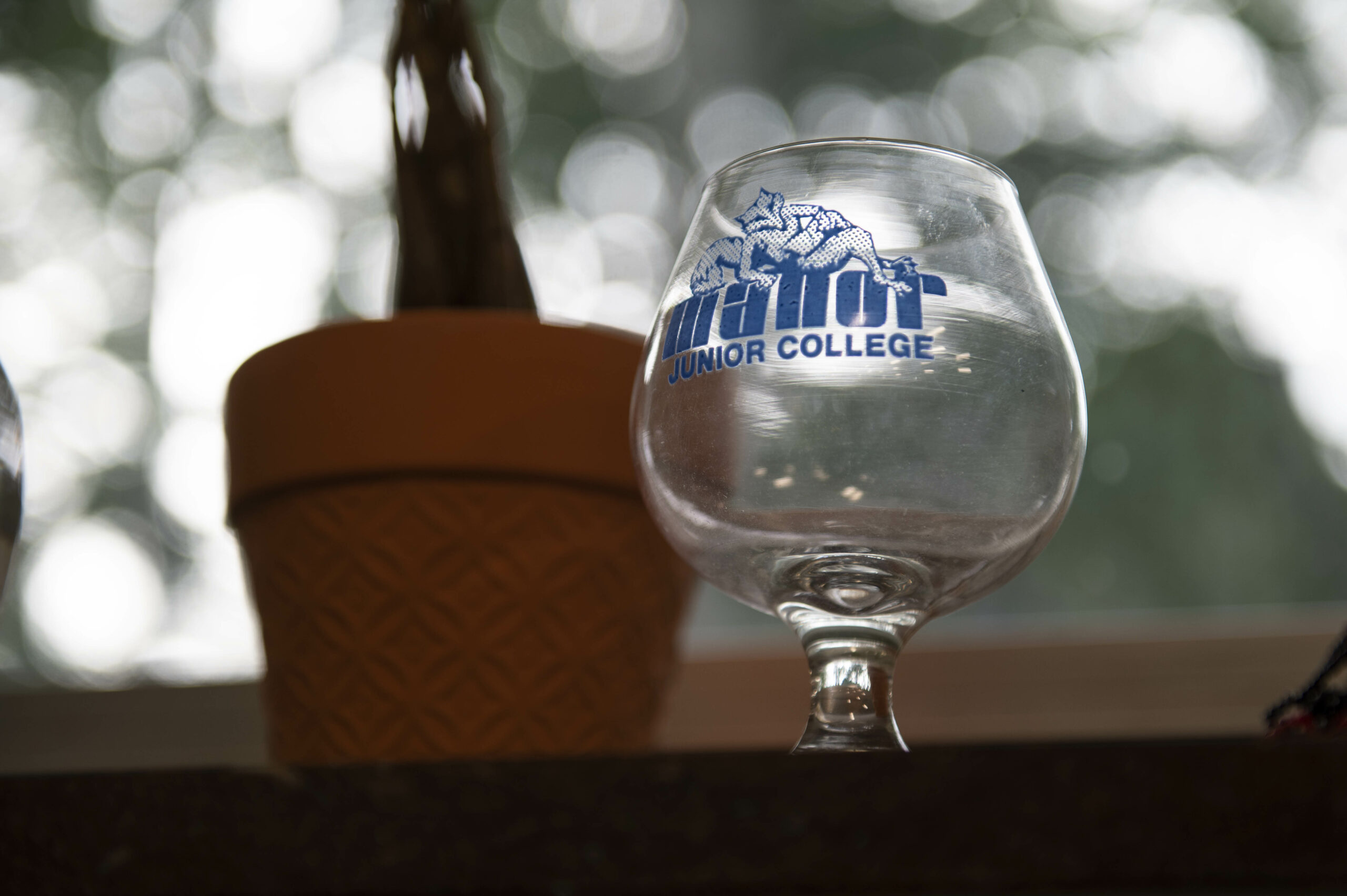 An old brandy glass with Manor Junior College written on it. 