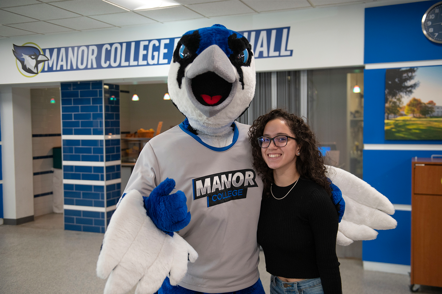woman smiling with a blue jay mascot