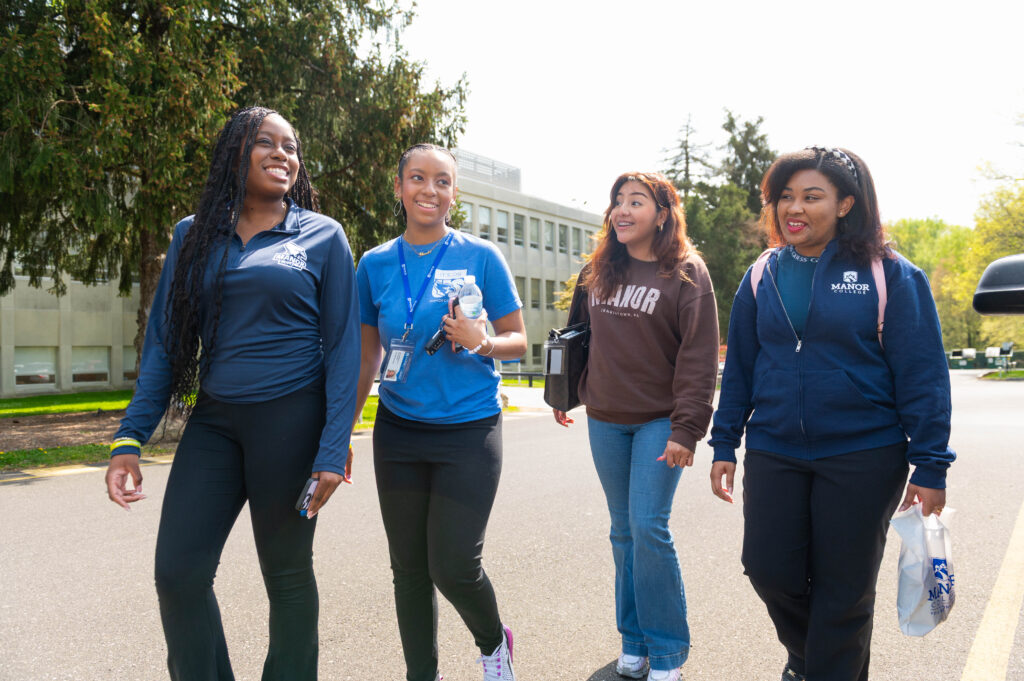 Four Manor students walking down a street.