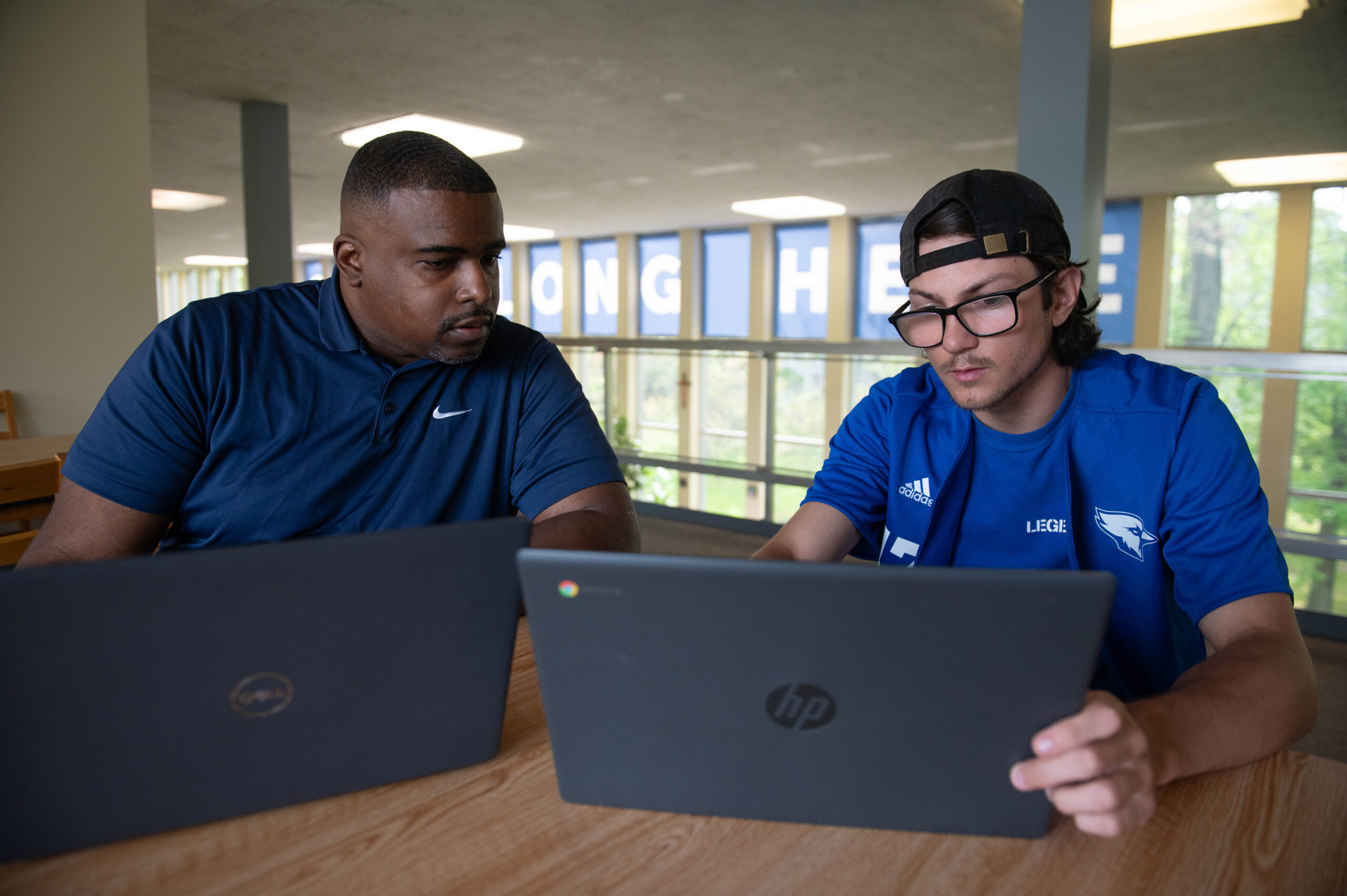 Manor Professor and Student working together in the library.