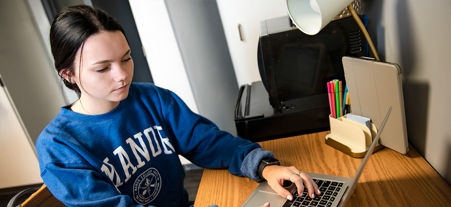 Manor College student studying in her dorm room.